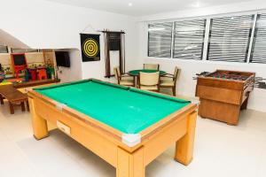 uma mesa de bilhar num quarto com cadeiras em The Falls Hotel no Guarujá