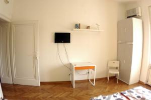 Habitación blanca con escritorio y nevera. en Bridge apartment, en Belgrado