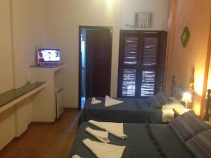 a hotel room with two beds and a television at Enseada Hotel in Ubatuba +35 photos