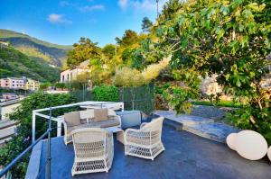 eine Terrasse mit Korbstühlen und einem Tisch auf dem Balkon in der Unterkunft Cinqueterre Residence in Riomaggiore