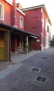 a red building with a patio in front of it at Al 54 in San Giorgio Di Mantova