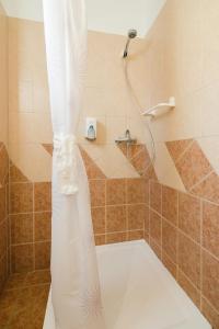 a shower with a white shower curtain in a bathroom at Alfr&eacute;d Panzi&oacute; in Budapest