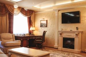 ein Wohnzimmer mit einem Schreibtisch und einem Kamin in der Unterkunft Gloria Business Hotel in Blagoweschtschensk