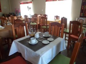 - une salle à manger avec une table avec des tasses et des soucoupes dans l'établissement El Cardon Hospedaje, à Huacalera