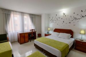 a hotel room with a bed and a desk and a bedroom at Hotel Florida Inn in Medellín