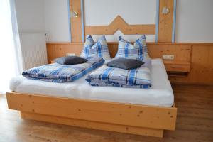 a bed with two pillows on top of it at Gästehaus Huber in Leogang