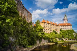 a building next to a river with a castle at Kristínka in Český Krumlov