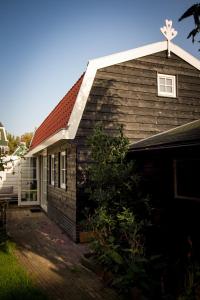 een huis met een gambrel dak en een garage bij Joans B&B in Zaandam