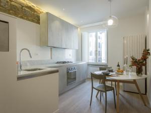 a kitchen with a table and a dining room at Mamo Florence - San Firenze Luxury Apartment in Florence