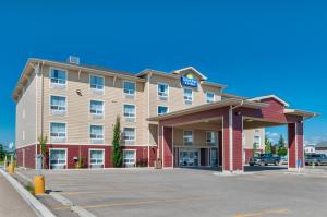 a hotel with a parking lot in front of it at Days Inn & Suites by Wyndham Cochrane in Cochrane