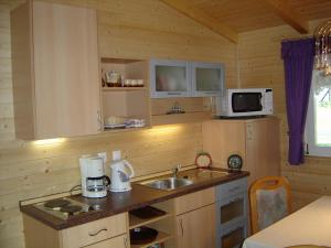 a kitchen with a sink and a microwave at Romantica in Drobollach am Faakersee