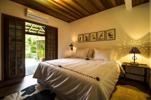 a bedroom with a large white bed in a room at Suites Caipira Vale das Videiras in Araras Petropolis