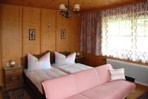 グロースキルヒハイムにあるhaus bergblickのベッドルーム1室(ピンクベッド1台、ピンクのソファ付)