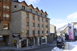 a building on the side of a street with snow at Apartaments Turistics Pirineu in Soldeu