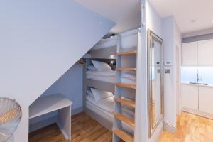 a staircase in a room with white walls and wooden shelves at Suites at number Ten in Broadstairs