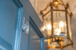 a blue door with a chandelier and a light at Suites at number Ten in Broadstairs