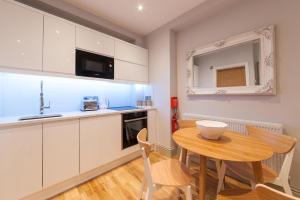a kitchen with a wooden table and a small dining room at Suites at number Ten in Broadstairs