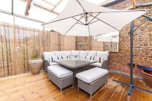 a patio with a table and chairs and an umbrella at Suites at number Ten in Broadstairs