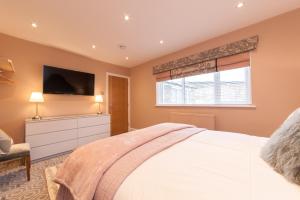 a bedroom with a bed and a tv on the wall at Suites at number Ten in Broadstairs