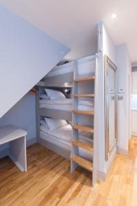 a room with a bunk bed with a desk and a mirror at Suites at number Ten in Broadstairs