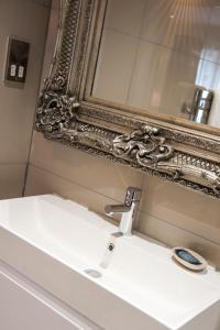 a bathroom with a sink and a mirror at Suites at number Ten in Broadstairs