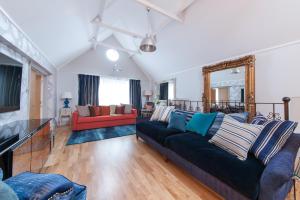 a living room with a black couch and a red chair at Suites at number Ten in Broadstairs