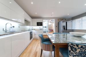 a kitchen with white cabinets and a table and chairs at Suites at number Ten in Broadstairs