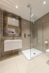 a bathroom with a sink and a shower and a mirror at Suites at number Ten in Broadstairs