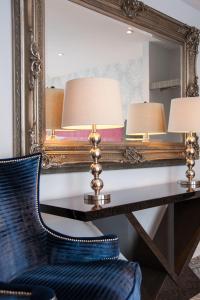 a mirror with two lamps and a chair in front of a desk at Suites at number Ten in Broadstairs
