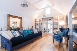 Suites at number Ten في برودستيرز: غرفة معيشة مع أريكة وكراسي زرقاء