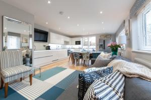 a living room with a couch and a kitchen at Suites at number Ten in Broadstairs