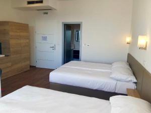 a hotel room with two beds and a kitchen at Bara Bay in Metajna
