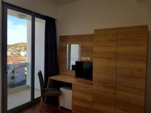 a room with a desk with a television and a large window at Bara Bay in Metajna