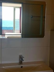 a bathroom with a mirror and a sink with a window at Bara Bay in Metajna