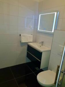 a bathroom with a sink and a toilet and a window at Bara Bay in Metajna