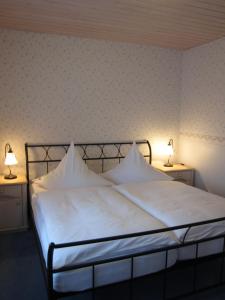 a bedroom with a white bed with two lights on it at Ferienwohnungen Oberwiesenthal in Kurort Oberwiesenthal