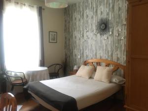 a bedroom with a bed with a wooden headboard at Pensión Leyre in Pamplona