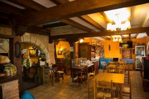 um restaurante com mesas e cadeiras num quarto em Trisileja en Puente Romano em Toñanes