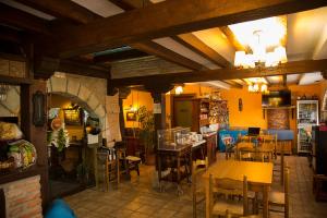 a restaurant with tables and chairs in a room at Trisileja en Puente Romano in Toñanes
