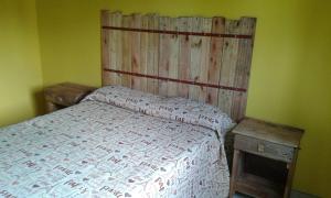 a bedroom with a bed with a wooden headboard at Casa Picoco in San Bernardo