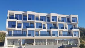 a white building with blue windows on the beach at Bara Bay in Metajna