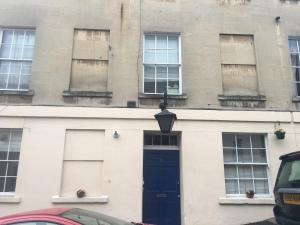 un edificio con una puerta y ventanas azules en 2 bed, ground floor Bijou Georgian city apartment, en Bath