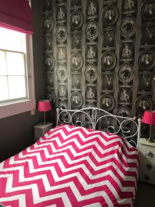 a bedroom with a red and white patterned bed and a wall at 2 bed, ground floor Bijou Georgian city apartment in Bath