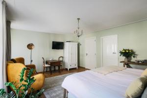 a bedroom with a bed and a table and a chair at De Verwennerie in Zierikzee