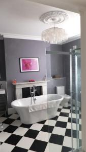 baño con bañera blanca y suelo a cuadros en blanco y negro en Te Papa, en Ramsgate