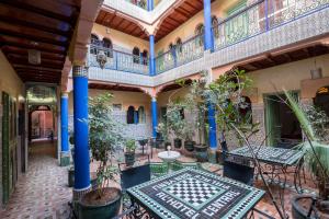 an indoor courtyard with tables and potted plants at Hotel Central Palace in Marrakech