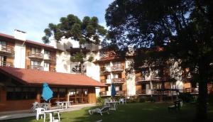 a building with tables and chairs in front of it at Gramado Serrano in Gramado