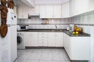 eine weiße Küche mit Spüle und Geschirrspüler in der Unterkunft Casa Lanza in Playa Honda + 11 Fotos