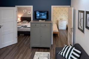 Zimmer mit einem Bett und einem TV auf einem Schrank in der Unterkunft Green House - Two Bedroom Apartment in Bielsko-Biała