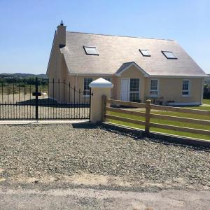 a house with a fence in front of it at Inish House in Malin Head